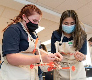 Two girls using beakers